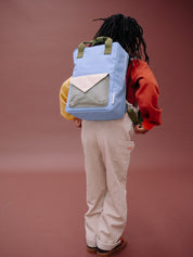 Person wearing a blue backpack with a plain background